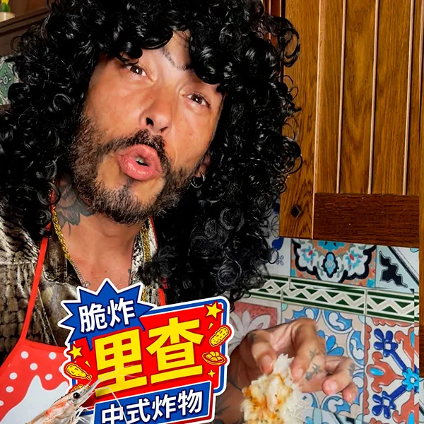 Er Richa, personaje de Ocurrensia, con un cartel de comida frita en chino