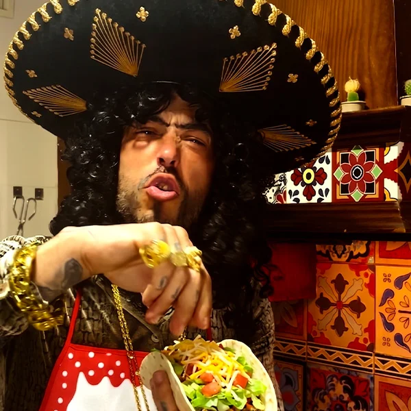 Pablo Nicasso caracterizado con sombrero mariachi comiendo tacos en un sketch de Ocurrensia